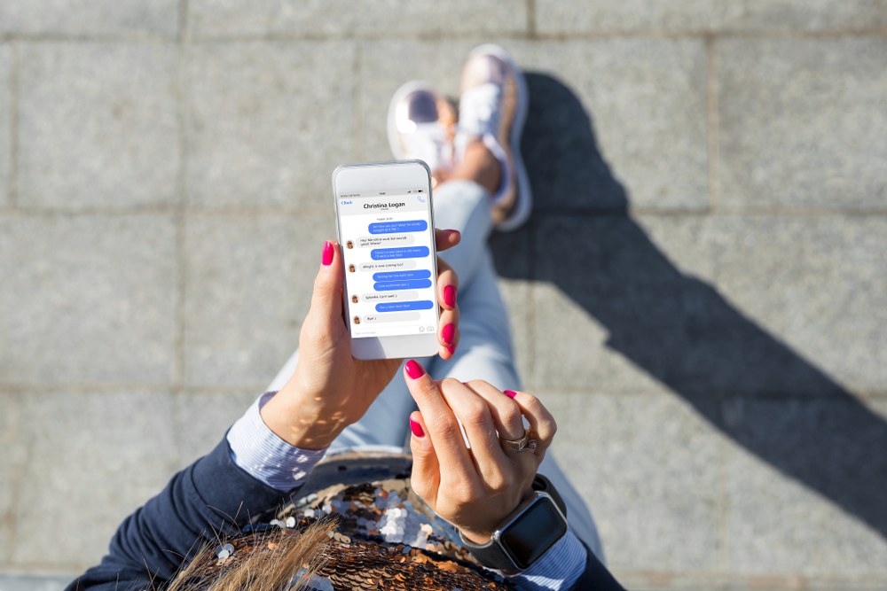 Person using a smartphone messaging app for in-app communication
