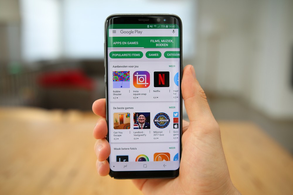 Person using a smartphone to browse the Google Play Store