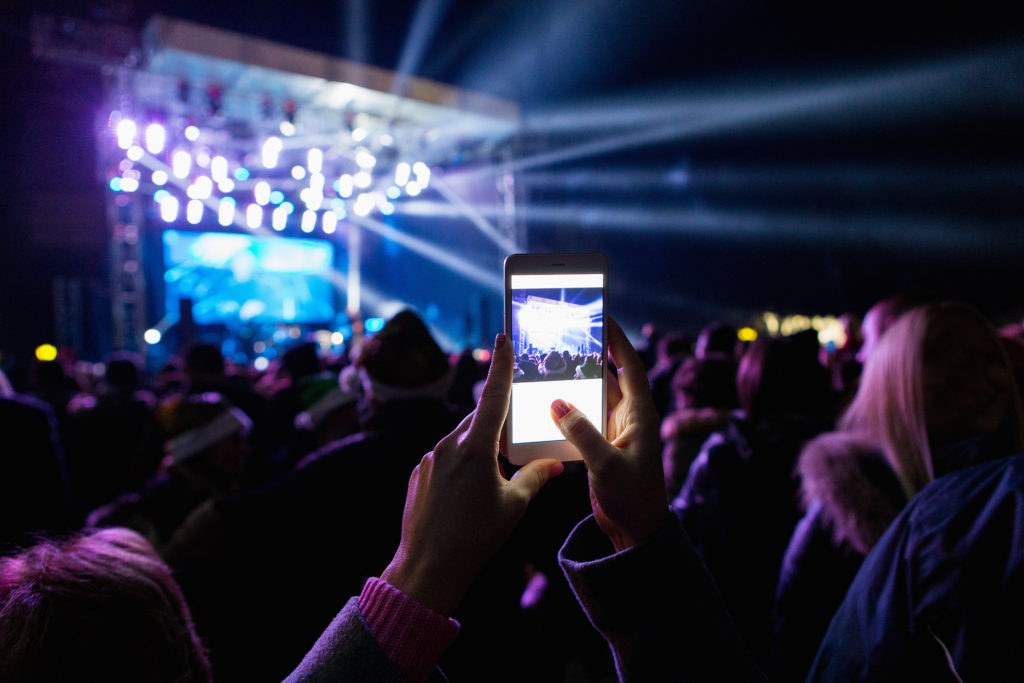 Attendees using smartphones at an outdoor conference or festival