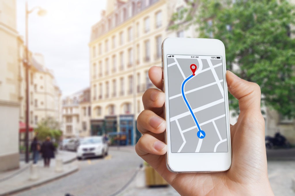 Person using a navigation app on a smartphone while driving