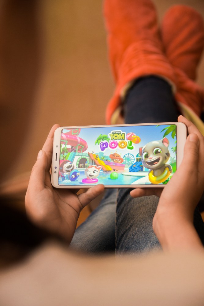 Person playing a mobile game with in-game ad overlay