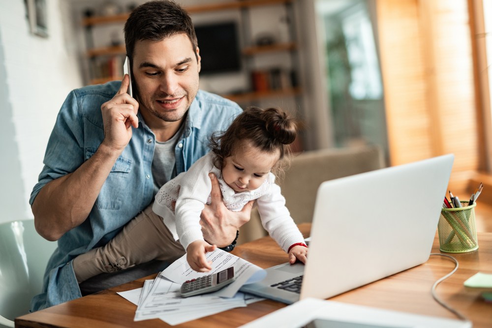 Parent and child interacting and smiling at a mobile device