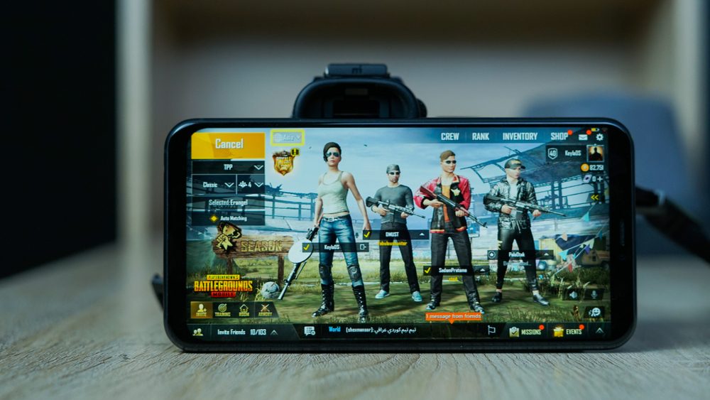 Family gathered around phones enjoying mobile games together