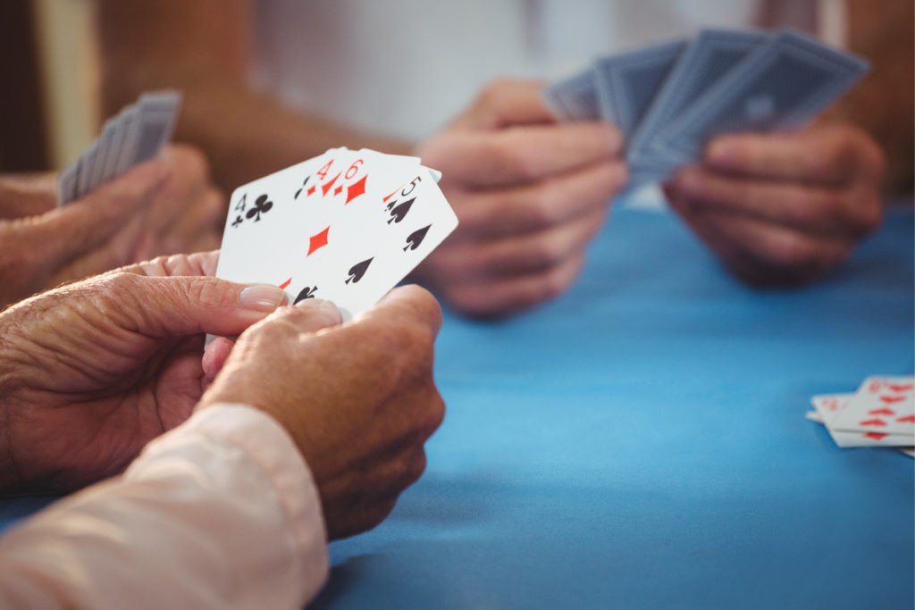 Friends gathered around a table playing card games together