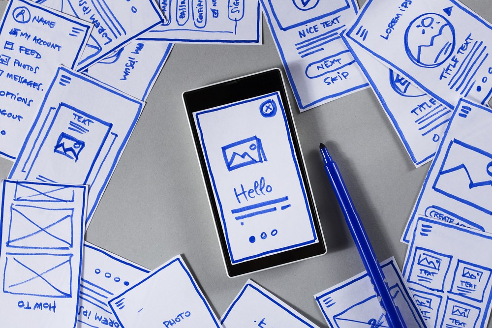 UI and UX designer sketching a mobile app interface wireframe
