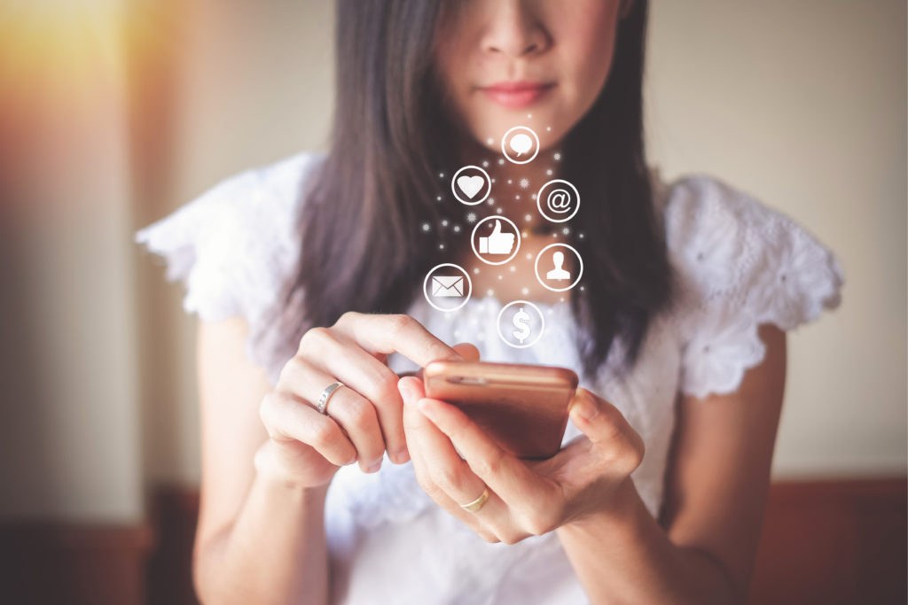 Person browsing social media on a smartphone at a desk