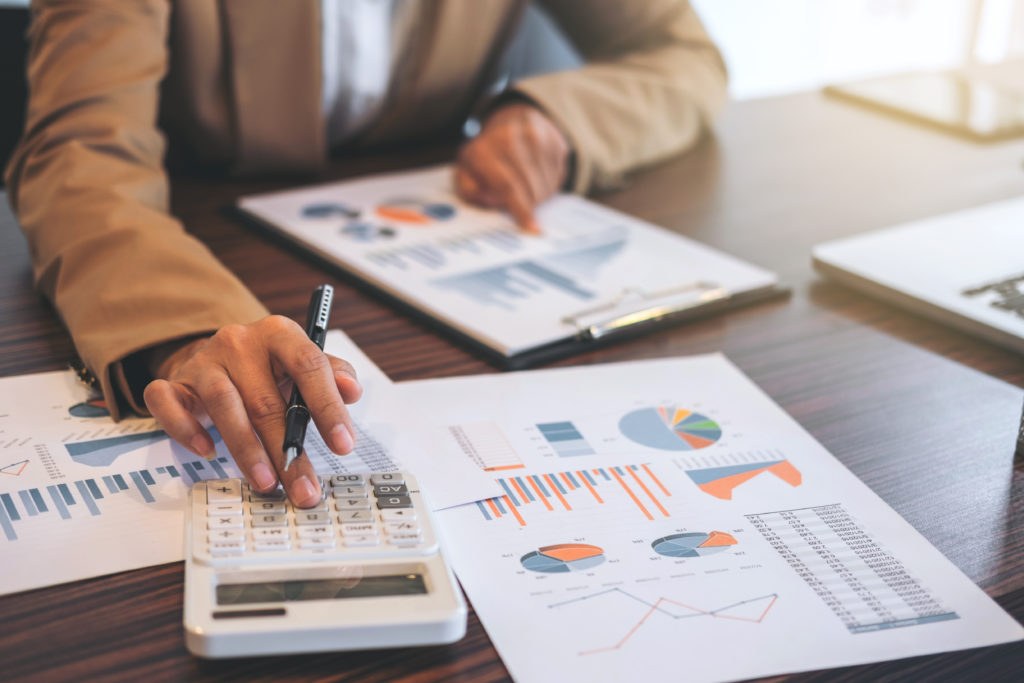 Person planning a marketing budget at a desk with a laptop