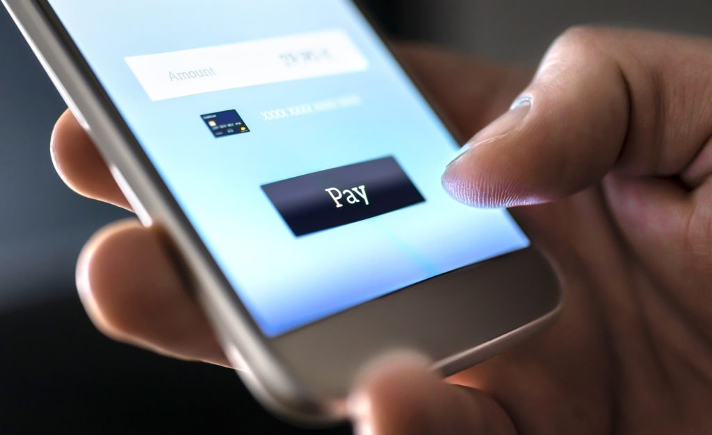 Hand of a person clicking the pay button of a app purchase