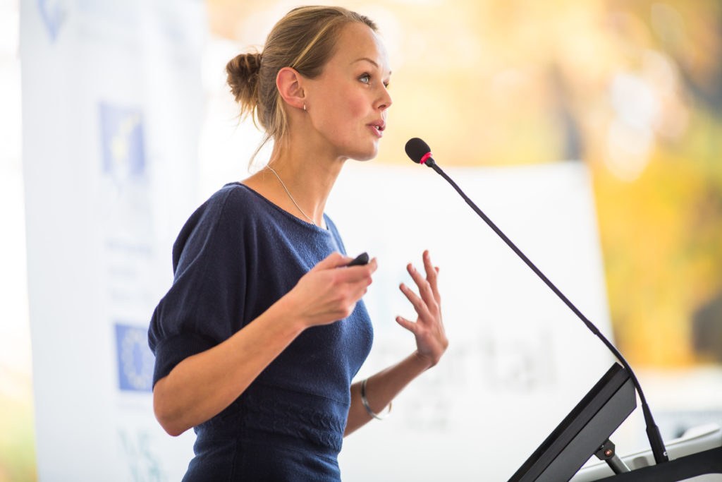 Young businesswoman talking before the media about the background story behind the app rebrand