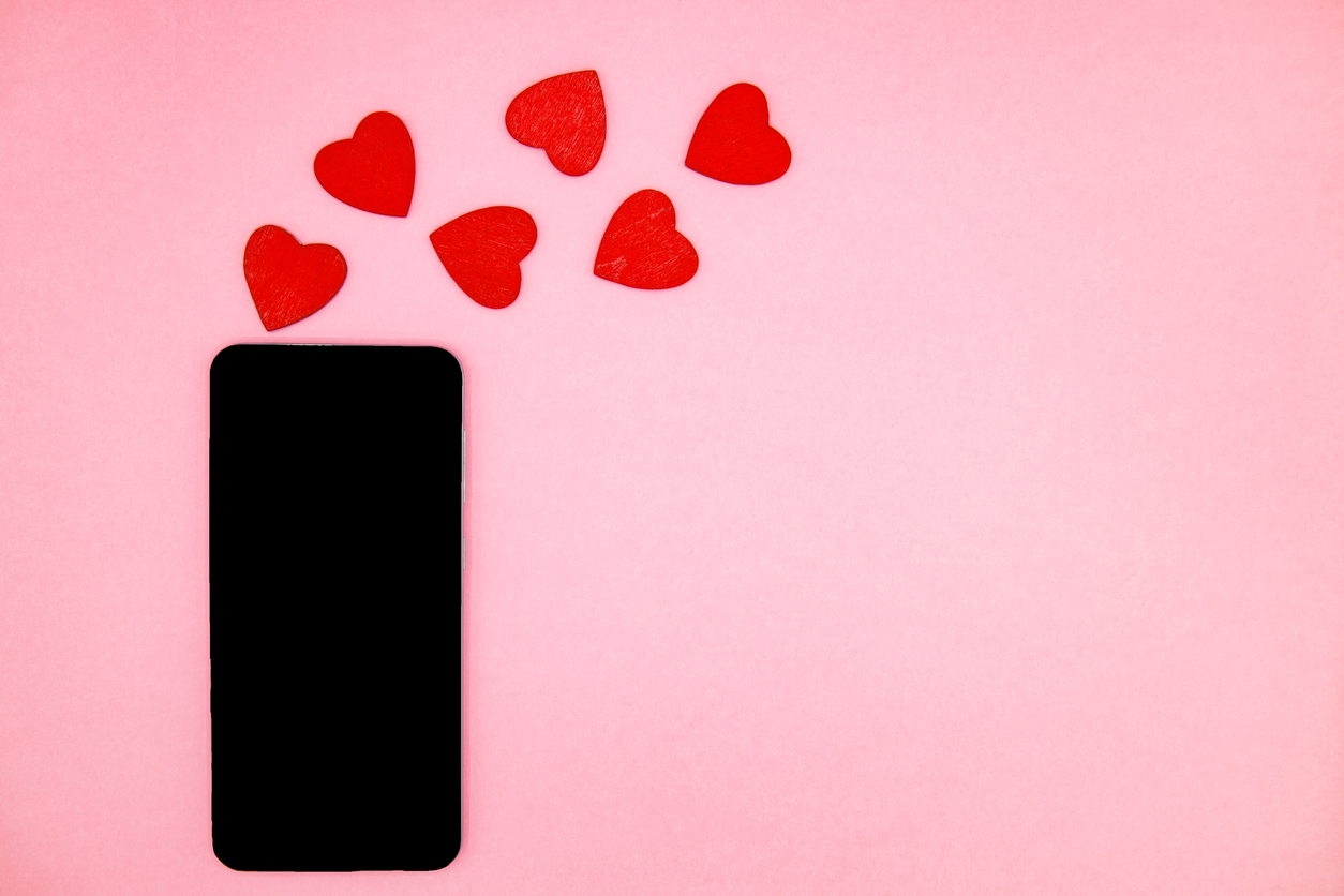 mobile-phone-with-blank-screen-and-red-hearts-shape-on-pink-background-valentines-day-concept